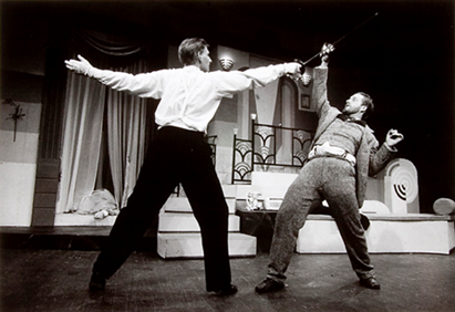 A person holding a sword with another person in the background

AI-generated content may be incorrect.