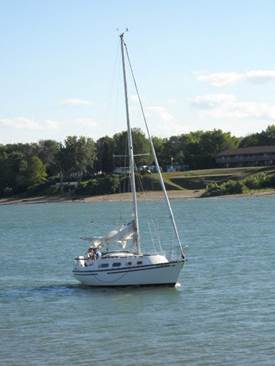 A small boat in a body of water

Description automatically generated