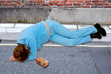 A person lying on a sidewalk

Description automatically generated